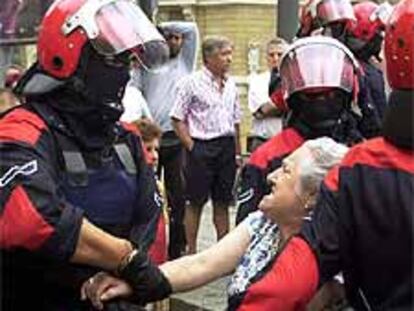 Varios <I>ertzainas</I> forcejean con una mujer en Bilbao.