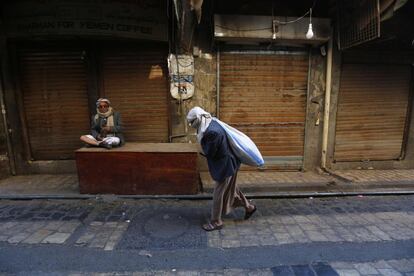 Un hombre porta un saco en un mercado de Saná (Yemen).