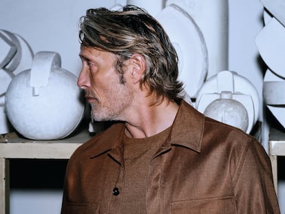 The actor Mads Mikkelsen, wearing a Zegna sweater and jacket, well surrounded by sought-after abstract sculpture.