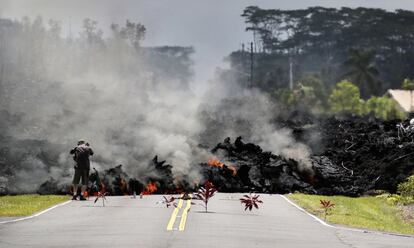 Un hombre fotografía la lava enfriándose sobre una carretera en el estado de Leilani, cerca de Pahoa, Hawái, el 5 de mayo de 2018.