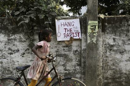 Una niña pasa junto a un cartel en el que se lee "Colgad al violador" en el muro de la escuela donde una monja fue agredida sexualmente en Ranaghat (India).