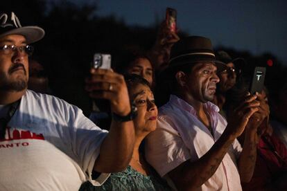 Un grupo de personas fotografía y graba con sus teléfonos celulares las labores de rescate, la noche del 28 de junio de 2022.