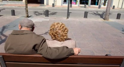 Una parella d'ancians pren el sol en un banc