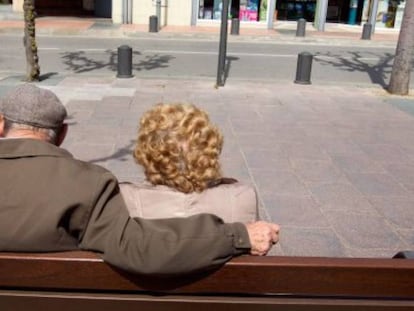 Una pareja de ancianos toma el sol en un banco