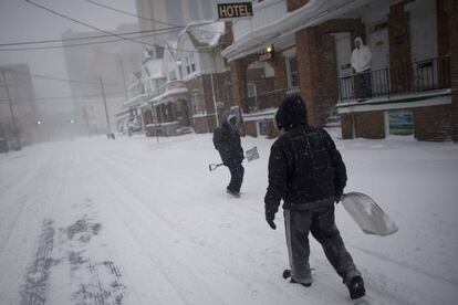 Dos hombre con palas de nieve en una calle de Atlantic City, Nueva Jersey, el 4 de enero de 2018.