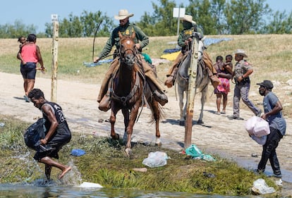 Dos agentes de la Patrulla Fronteriza persiguen haitianos el domingo 19 de septiembre de 2021. 