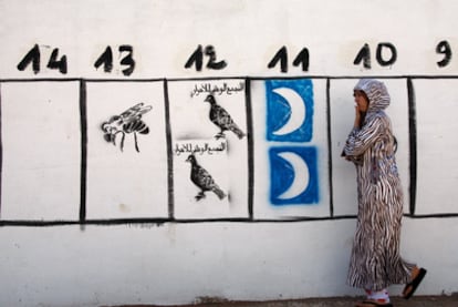 Una mujer pasa en Rabat ante dibujos de propaganda electoral en vísperas de las municipales de junio de 2009 en Marruecos