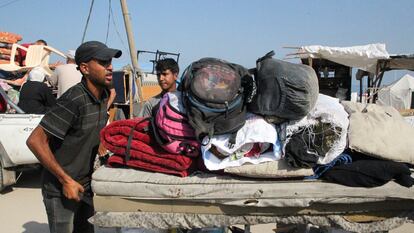 Palestinos viajan a pie con sus pertenencias mientras huyen de Rafah debido a una operación militar israelí, el pasado 13 de junio.