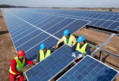 Cuatro trabajadores instalan un panel solar. EFE/Archivo