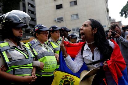 Una manifestante reacciona frente a varias agentes de la policía antidisturbios durante la marcha de mujeres contra Maduro el 6 de mayo de 2017 en Caracas.