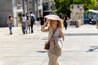 Una mujer se protege del sol con un abanico por el centro de Madrid, este miércoles.