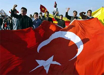 Varios manifestantes despliegan una bandera de Turquía durante una protesta contra la guerra.