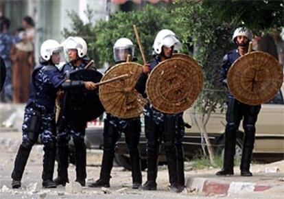 Agentes de policía palestinos se preparan para hacer frente a los manifestantes.