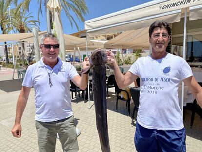 Sebastián Martin (izquierda) con Pepe, amigo pescador con un congrio vivo a la puerta del restaurante Chin Chin. J.C.CAPEL