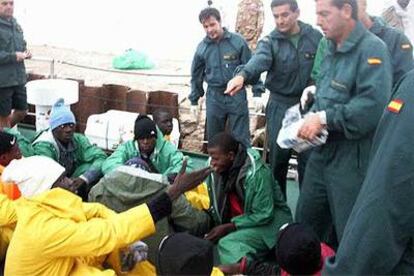 Guardias civiles de la <i>Río Duero</i> dan alimentos a los senegaleses hallados el martes a la deriva en Cabo Blanco.