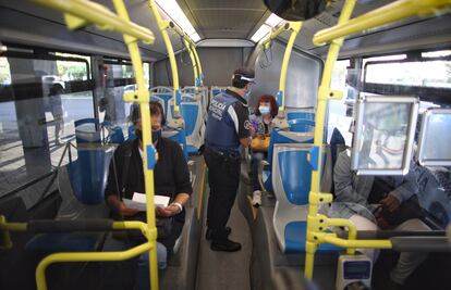 Un municipal realiza un control de movilidad en un autobús en el distrito de Puente de Vallecas.