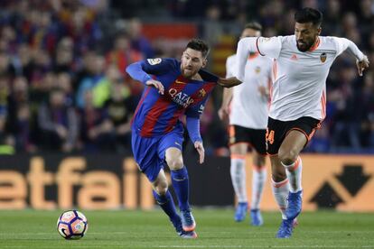 Lionel Messi, del FC Barcelona, pelea el balón con el Ezequiel Garay del Valencia.