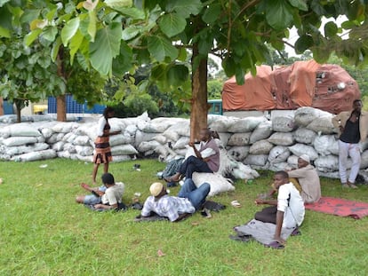 Comerciantes sentados junto al carbón incautado tras la prohibición frente a las oficinas regionales de la Autoridad Forestal Nacional en la ciudad de Gulu, en el norte de Uganda.
