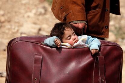 Un nño duerme en una maleta en Beit Sawa, Guta Oriental (Siria).