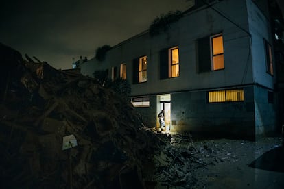 Un vecino vigila la entrada del portal de su casa mientas cambian la cerradura del inmueble.