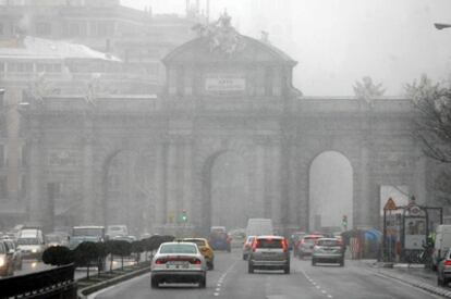 Imagen de la Puerta de Alcalá durante la nevada caída esta mañana en Madrid.