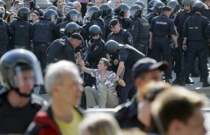 Varios agentes de la policía rusa levantan a un joven del suelo durante una protesta contra Vladimir Putin en el centro de Moscú (Rusia).