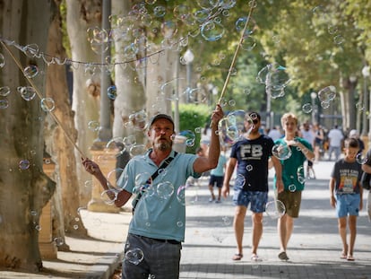 SEVILLA, 04/08/2025.- Un hombre hace pompas de jabón para los turistas este lunes de Sevilla, al inicio de la segunda ola de calor de este verano con temperaturas que superan los 40 grados. La persistencia de una masa de aire cálido procedente del norte de África, combinada con un bloqueo anticiclónico sobre la península, agravará la sensación térmica durante toda la semana. EFE /Jose Manuel Vidal