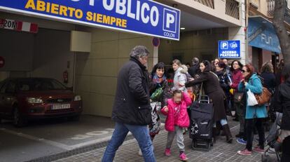 Madres y alumnos del colegio San Juan de Ribera de Valencia, situado junto a la salida de un aparcamiento.