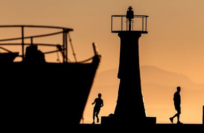 Siluetas de dos personas en el puerto de Kalk Bay, en Ciudad del Cabo (Sudáfrica).