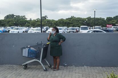 Una mujer con mascarilla habla por teléfono con el carro de la compra a su lado en el aparcamiento de un supermercado de Eshowe, en Sudáfrica. Sudáfrica vivió un largo confinamiento domiciliario que, como en tantos otros lugares, afectó de lleno a su economía, la cual ya arrastraba problemas desde antes, pues se halla en recesión desde 2017. Es el más industrializado de África, pero también es un país donde 30,8% de la población está en paro (y es la cifra más alta desde 2008), y donde al menos 2,5 millones de personas, según el Departamento de Estadística del Gobierno, sobrevive gracias a la informalidad, es decir: si no trabajan un día, no ganan dinero y no comen al siguiente. Hasta ahora, el impacto de las medidas ha supuesto una pérdida de más de 600.000 puestos de trabajo en el sector formal y según las Naciones Unidas, el PIB puede desplomarse hasta un 8% por el impacto de la pandemia.