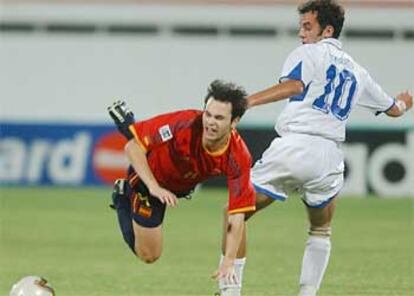 Iniesta (izqda) es derribado por un jugador de Uzbekistán durante el partido de esta tarde.