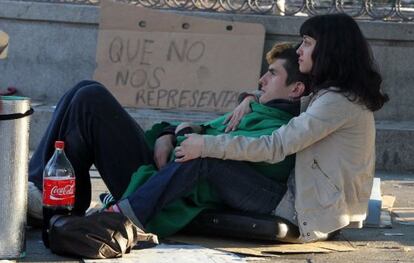 Dos j&oacute;venes en la Puerta del Sol en mayo con una pancarta con el lema &quot;Que no nos representan&quot;.