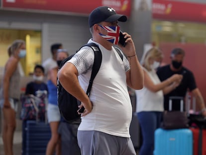 Un viajero habla por teléfono mientras espera la información de su vuelo de vuelta al Reino Unido, el 26 de julio en el aeropuerto de Tenerife.