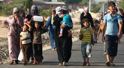 Refugiados sirios salen de la ciudad turca de Kilis, este domingo.