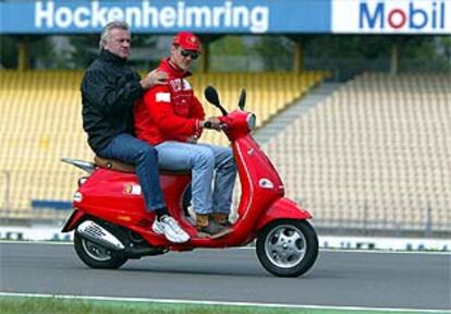 Schumacher y su <b></b><i>manager,</i> Willi Weber, inspeccionan ayer en moto el circuito de Hockenheim.