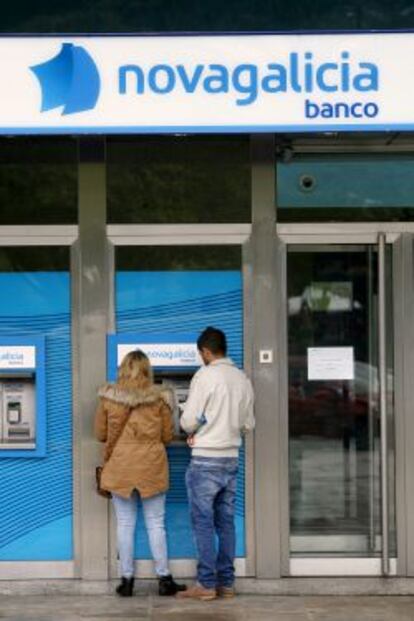 Dos clientes retiran dinero de un cajero de Novagalicia Banco en A Coru&ntilde;a