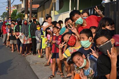 Un grupo de musulmanes indonesios hacen cola para recibir comida gratis a la hora en la que se acaba el ayuno durante el Ramadán en Yakarta (Indonesia).