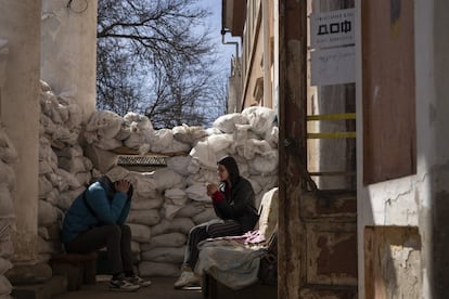 Dos jóvenes sentados en el exterior de un centro de voluntarios ucranios, protegido con sacos de arena, en Mikolaiv, el lunes. El director general del Organismo Internacional de la Energía Atómica (OIEA), el argentino Rafael Grossi, se encuentra en Ucrania para mejorar la seguridad de las centrales y "prevenir el peligro de un accidente nuclear" en el país, inmerso en una guerra desde la invasión rusa del 24 de febrero.