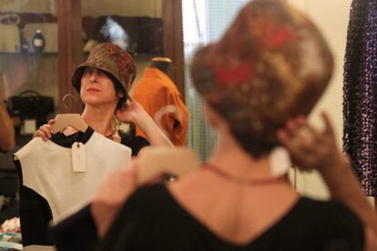 Una mujer se prueba un sombrero con una estética que está a décadas de la actual