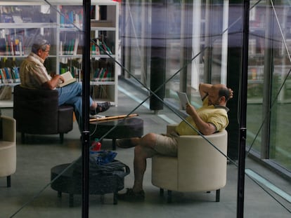 Dos personas leen en la biblioteca municipal Eugenio Trías, situada en la antigua casa de fieras de El Retiro, en Madrid.