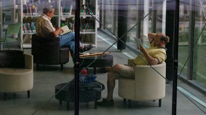 Dos personas leen en la biblioteca municipal Eugenio Trías, situada en la antigua casa de fieras de El Retiro, en Madrid.