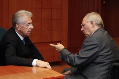 Mario Monti (izquierda) conversa con el ministro de Finanzas alemán, Wolfgang Sachäuble, ayer durante el Eurogrupo.