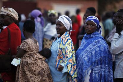 Varias personas esperan para votar en un colegio electoral, ayer en Kigali.