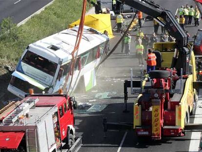 Una grúa endereza el autobús volcado en el accidente ocurrido en la carretera de Burgos.