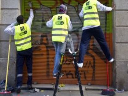 Tres participantes en el plan de limpieza en la calle de Sant Pere m&eacute;s Baix.