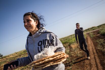 Delal y un joven que vive en uno de los pueblos vecinos, llevando el pan recién horneado de la panadería a la pequeña tienda en Jinwar.