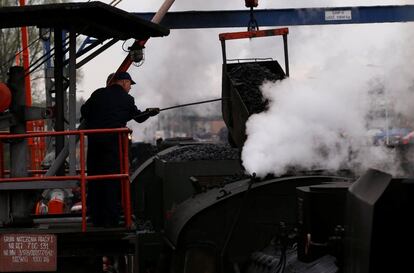 Trabajadores depositan el carbón en el interior de las locomotoras, listas para el desfile de Wolzstyn.