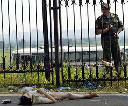 Un policía ruso observa el cuerpo de una de las terroristas, a las puertas del recinto en el que se celebraba el concierto.