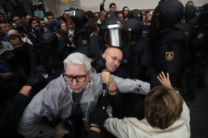 A Polícia Nacional desaloja pessoas de uma escola em Barcelona. Algumas pessoas haviam passado a noite no centro de votação para evitar que eles fossem fechados.