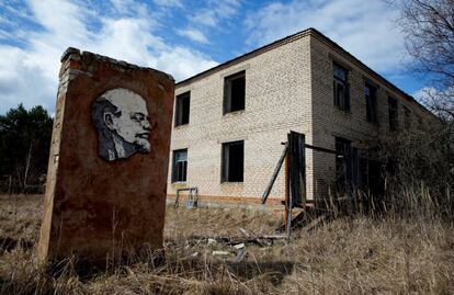 Un muro con un retrato del líder d ela Revolución rusa Vladímir Lenin junto a un edificio abandonado en la zona de exclusión de la central nuclear de Chernobyl, en la localidads abandonada de Orevichi (Bielorrusia).